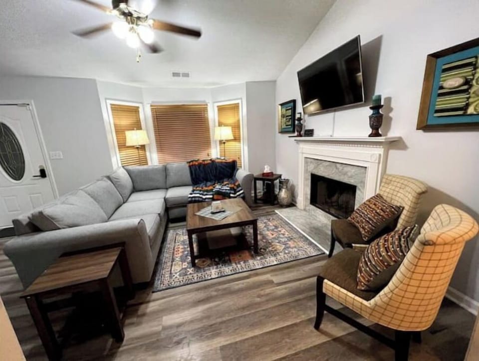 Living room with a cozy sectional sofa, smart TV, two chairs