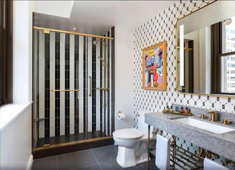 Refresh in a sunlit bath with brass details and rainfall shower.