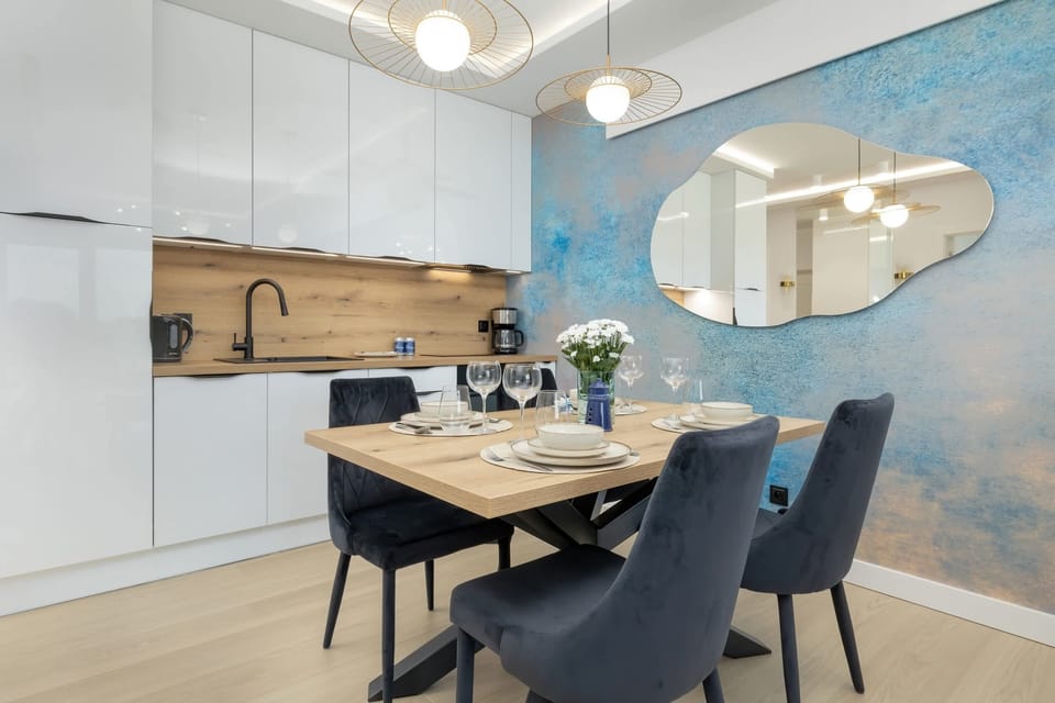 A bright and functional kitchen with white cabinets, wooden countertops, and sleek appliances, perfect for preparing meals.

