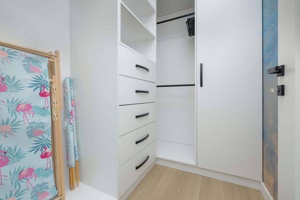 A walk-in closet with ample storage, bright lighting, and a cheerful splash of color from a decorative element.

