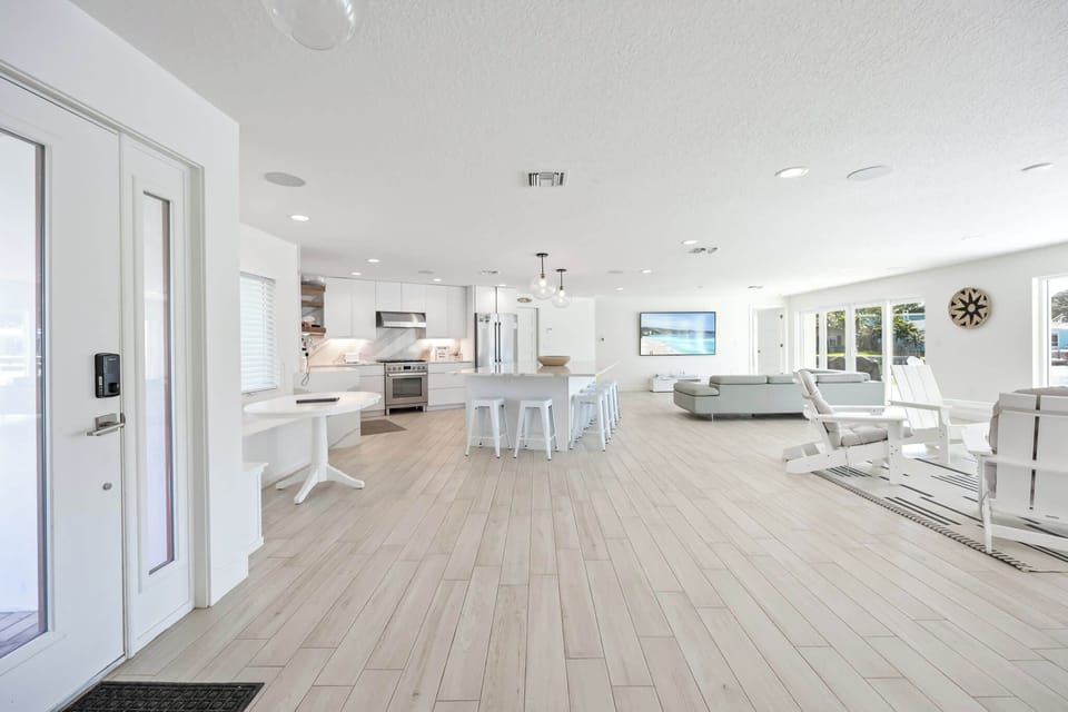 Open-concept modern kitchen and living area with natural light and coastal decor.
