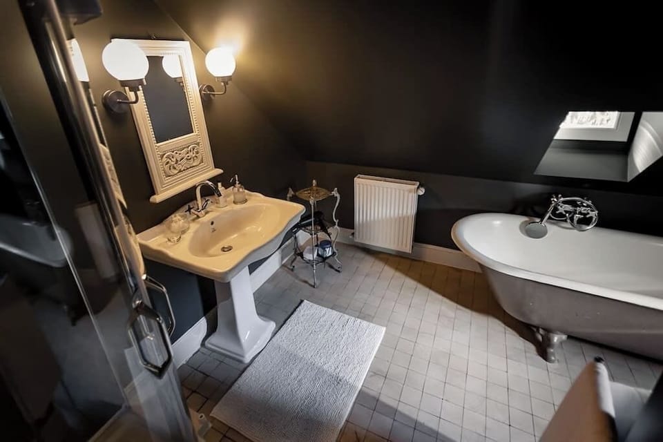 Bathroom with stand alone tub, walk in shower, toiletries and towels.