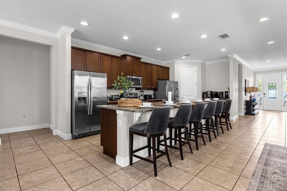 Stylish gourmet kitchen equipped with top-of-the-line appliances, dual refrigerators, and a large island with plenty of seating, ideal for preparing meals and entertaining guests.