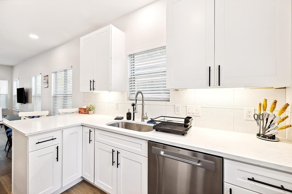 Fully stocked kitchen with dishwasher, white cabinets, and plenty of counter space. Perfect for short or long stays.