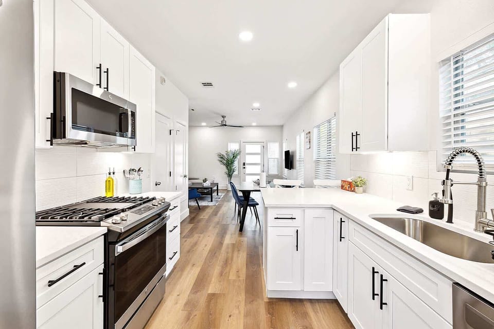 Modern kitchen with stainless appliances, ample counter space, and sleek white cabinetry. Fully equipped for cooking and entertaining.