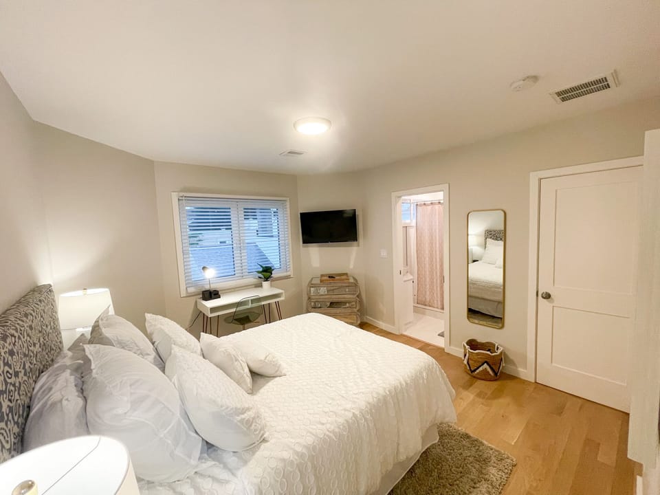 Bedroom 2: Mounted TV queen bed and work space, bathroom is attached to this bedroom