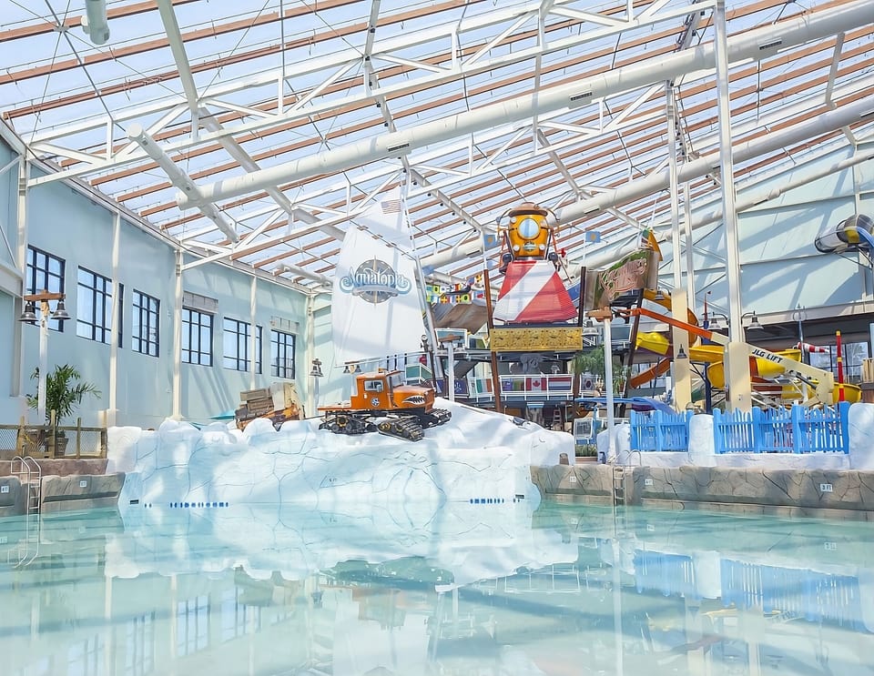 Drift through the bright indoor waterpark under sunlit beams.