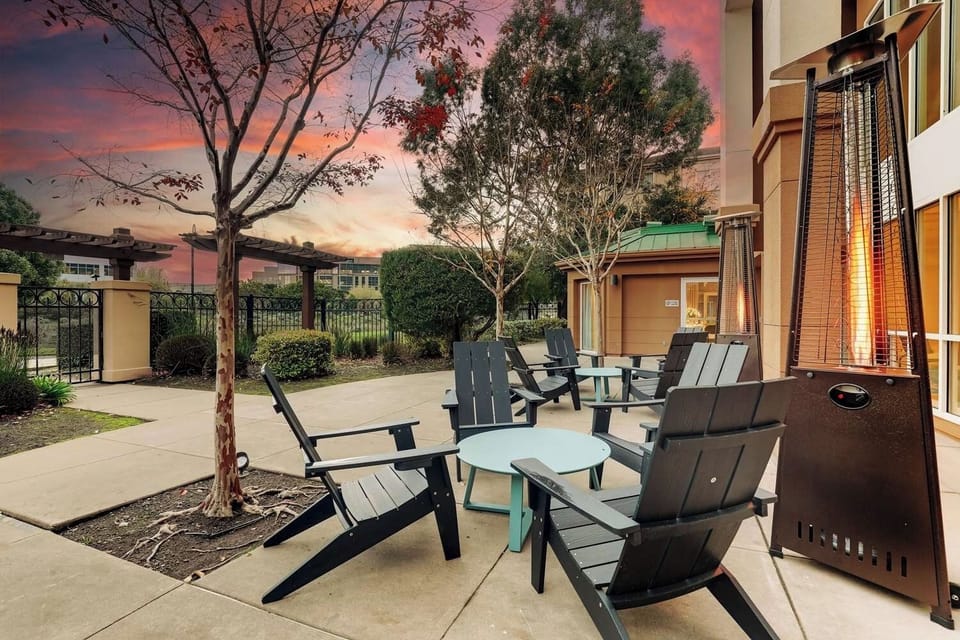 Unwind at sunset beside cozy heaters and lounge chairs.