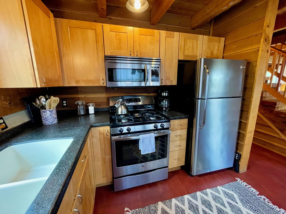 Fully-stocked kitchen with gas range, dishwasher, and ample cookware and dishes.
