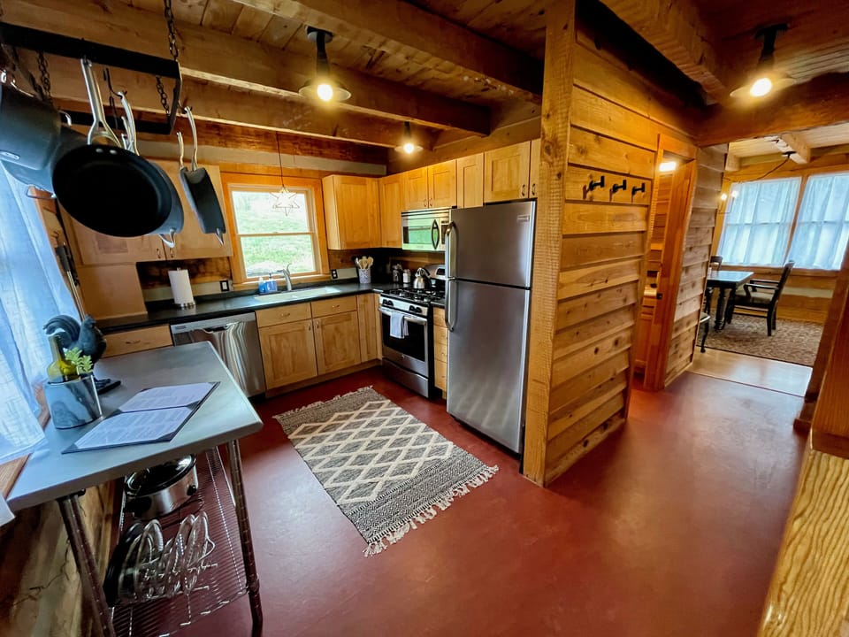 Fully-stocked kitchen with gas range, dishwasher, and ample cookware and dishes.
