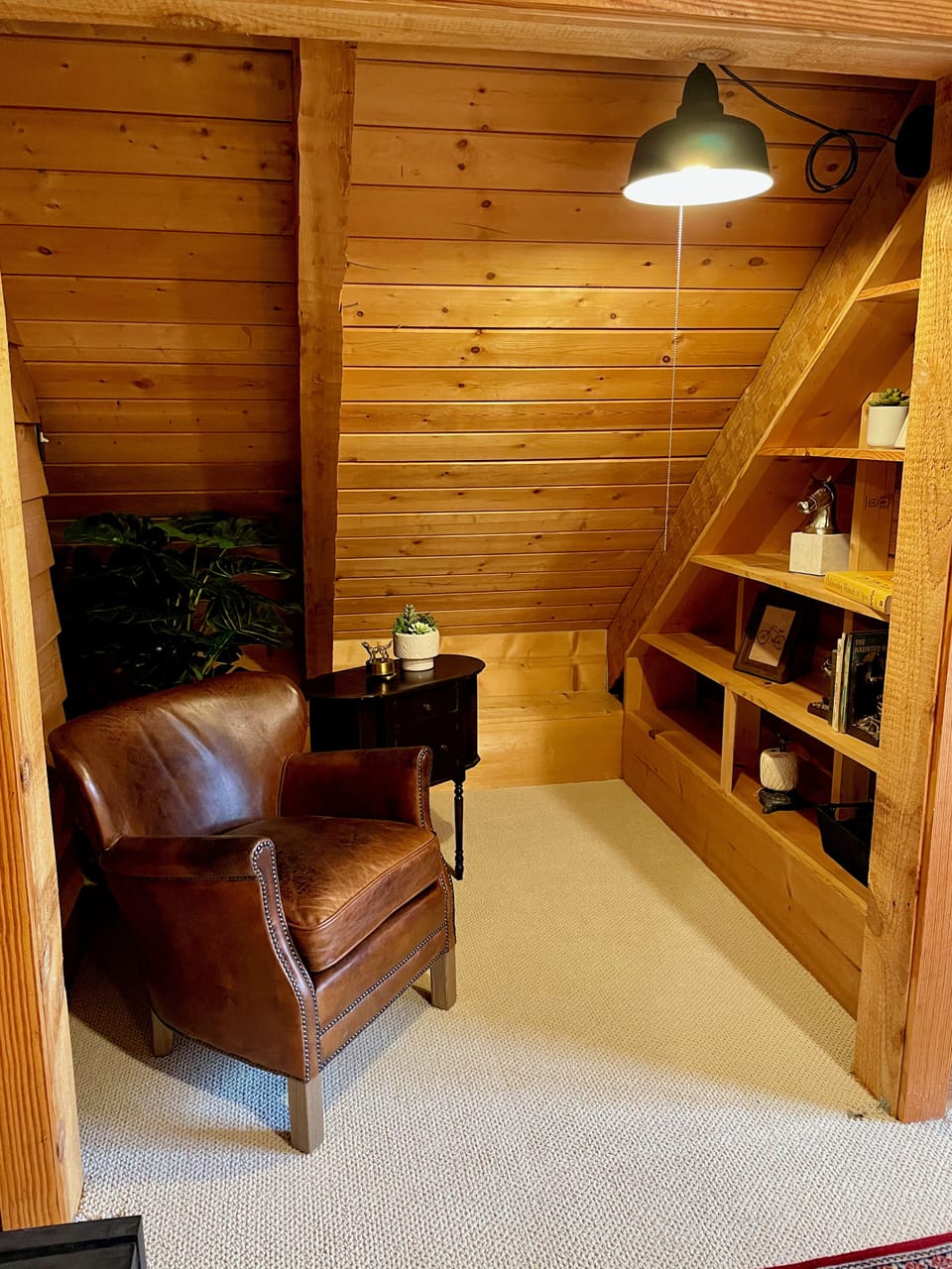 An upstairs bedroom features a reading nook with a comfy leather chair.