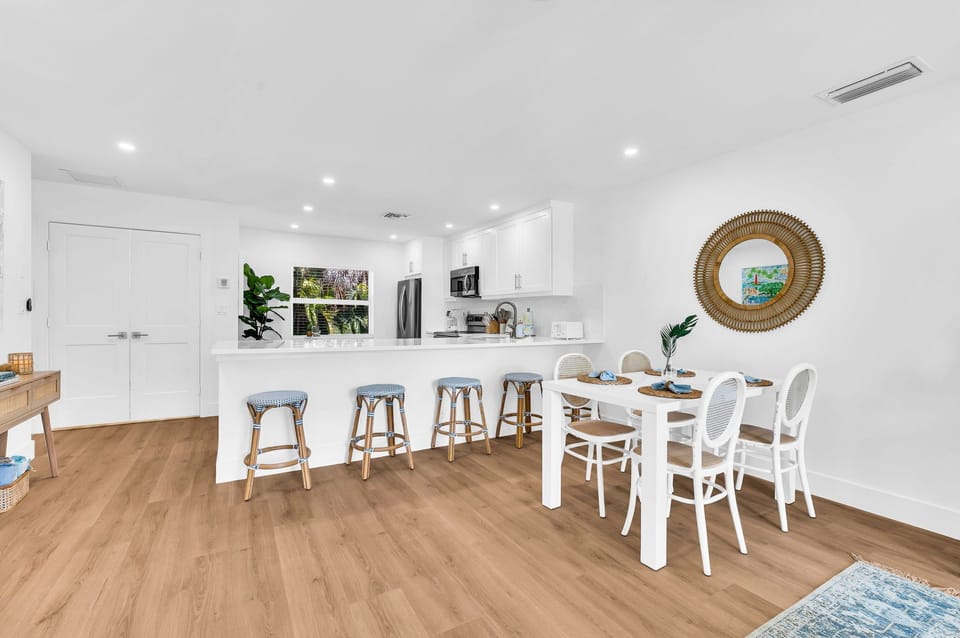 There are 5 sky-blue rattan bar stools at the impressively large quartz kitchen counter.