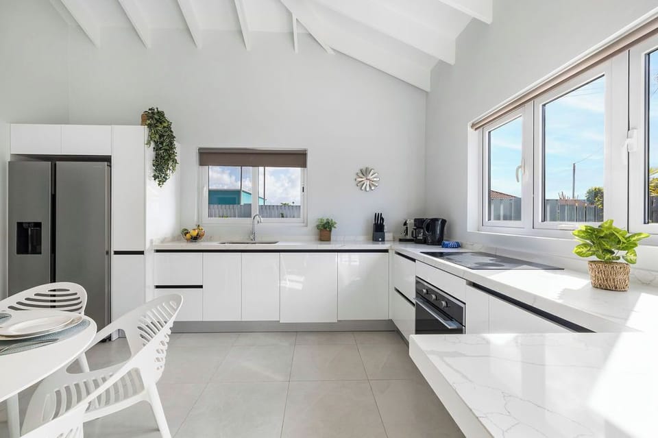 This bathroom comes with complete amenities, a toilet, and a shower with a glass partition.