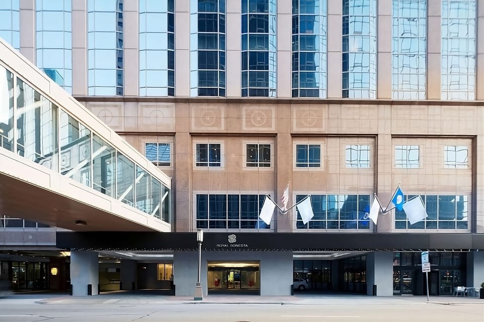 Arrive confidently at a polished downtown entrance with welcoming flags.