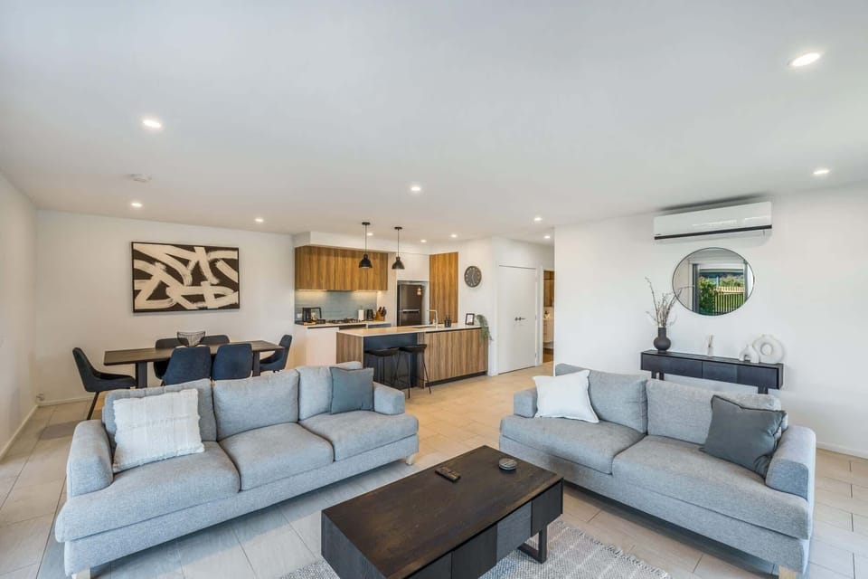 Dual-Sofa lounge features two plush, light-grey couches arranged around a central dark-wood coffee table.