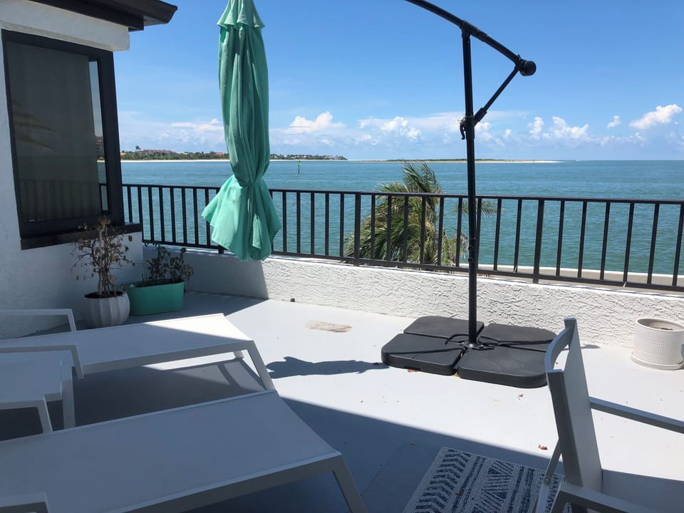 Lanai with lounge chairs and opening umbrella 
