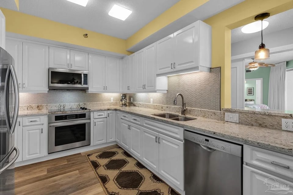 The fully equipped kitchen has stainless appliances and granite countertops.