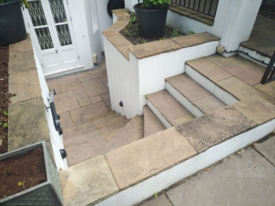10 steps leading from the garden path down to the front entrance under the arch