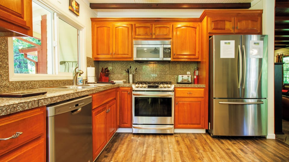 Large kitchen with granite counters, stainless appliances and wood cabinets.