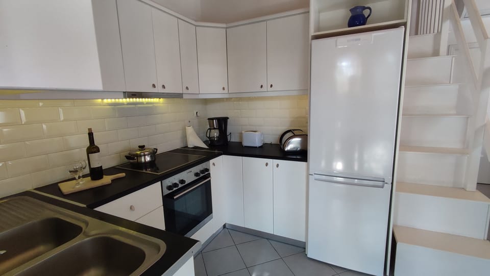 Inside kitchen with ceramic hob also  showing stairs  to mezzanine 