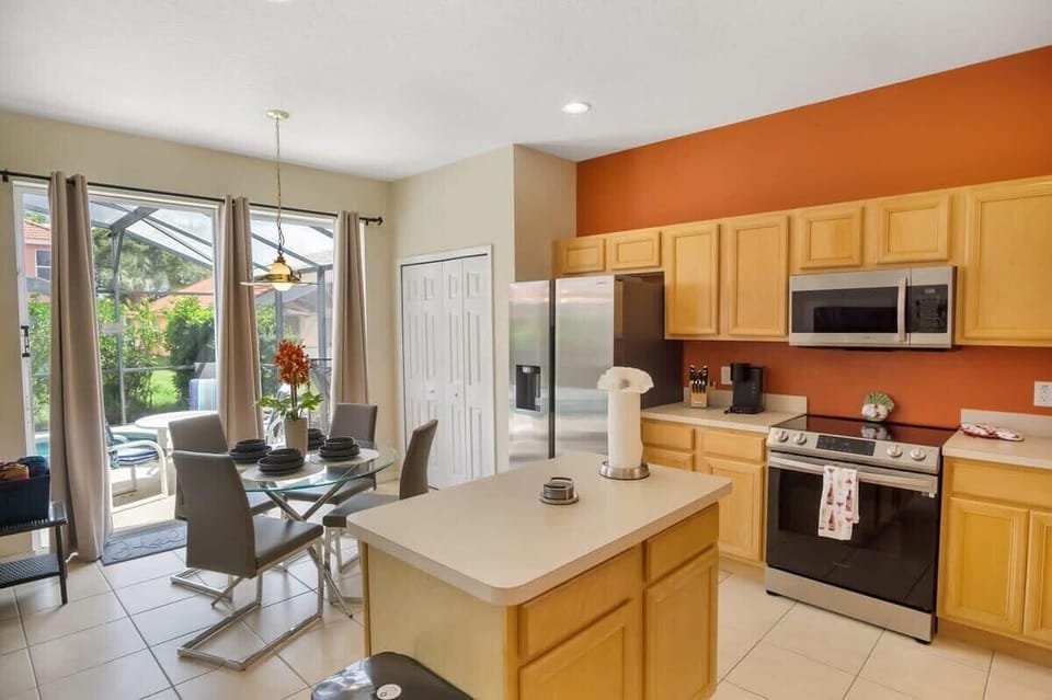 Bright and modern kitchen with sleek appliances and a cozy dining area, perfect for enjoying meals with a view of the patio.