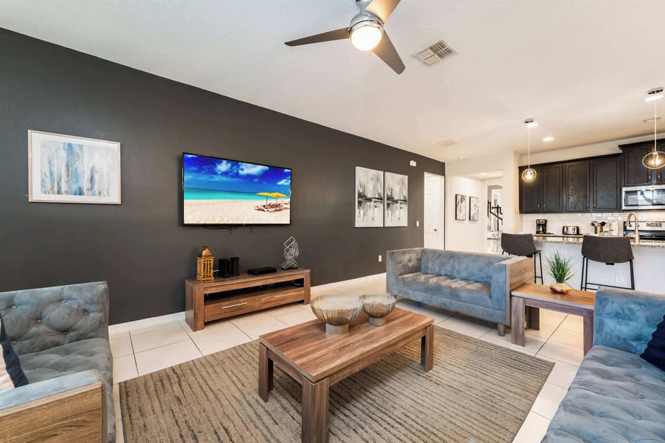 Stylish living room with modern decor, comfy seating, and open kitchen access, ideal for entertaining.