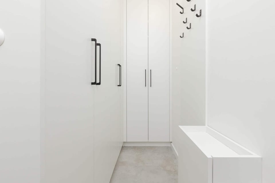 A bright and spacious hallway with built-in storage cabinets and a clean, minimalist design.

