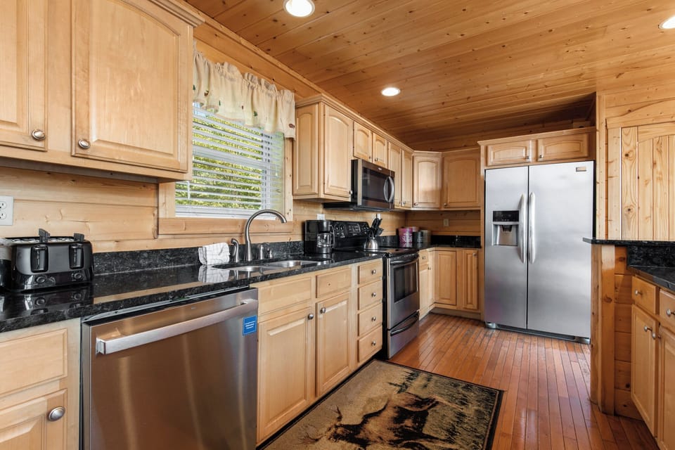 Fully Equipped Kitchen with Stainless Steel Appliances and Breakfast Bar Seating for Four