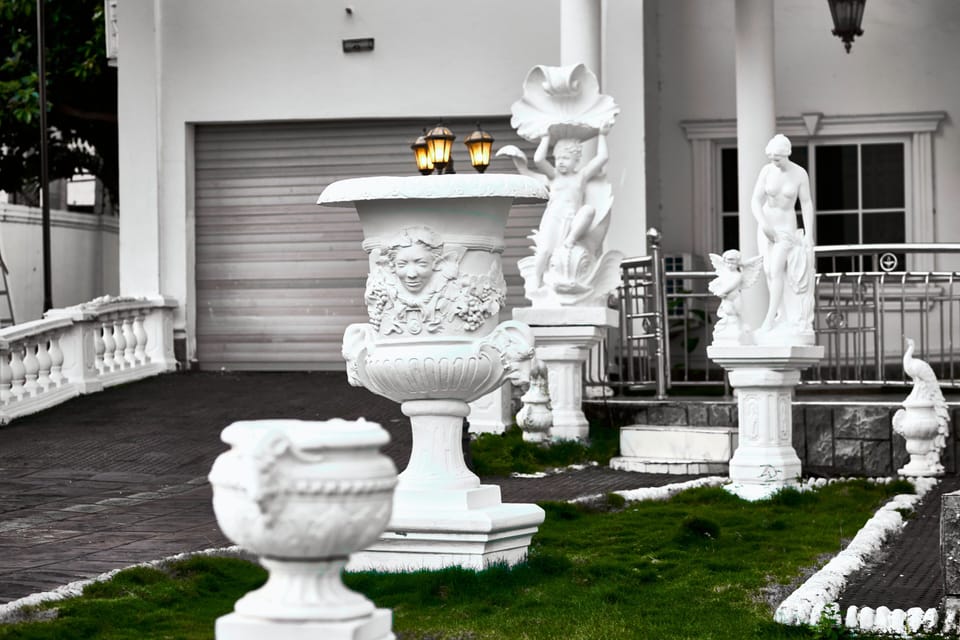 Front entrance with giant ornate Bacchus French urn in view: The Peacock Mansion