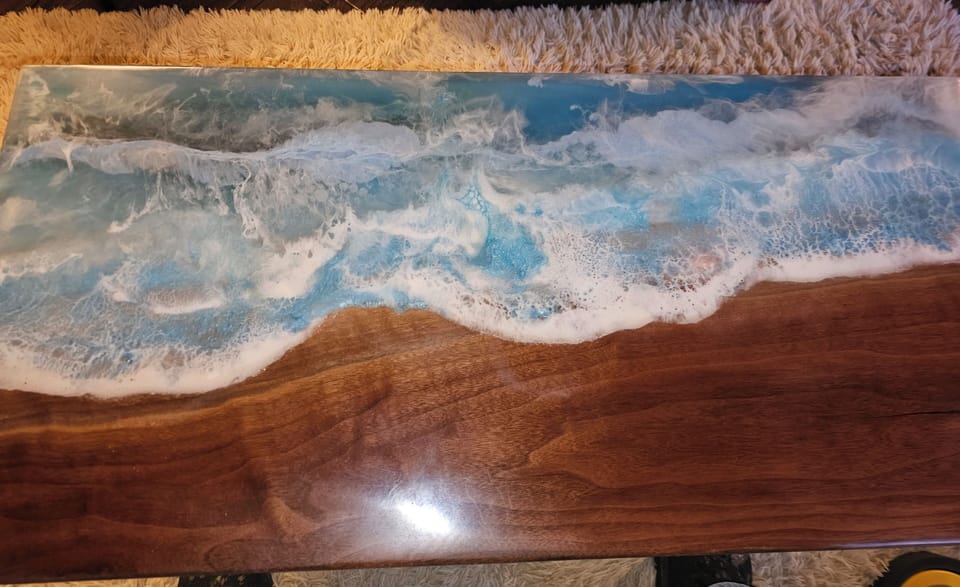 The coffee table I made with walnut and epoxy of a shoreline with crashing waves