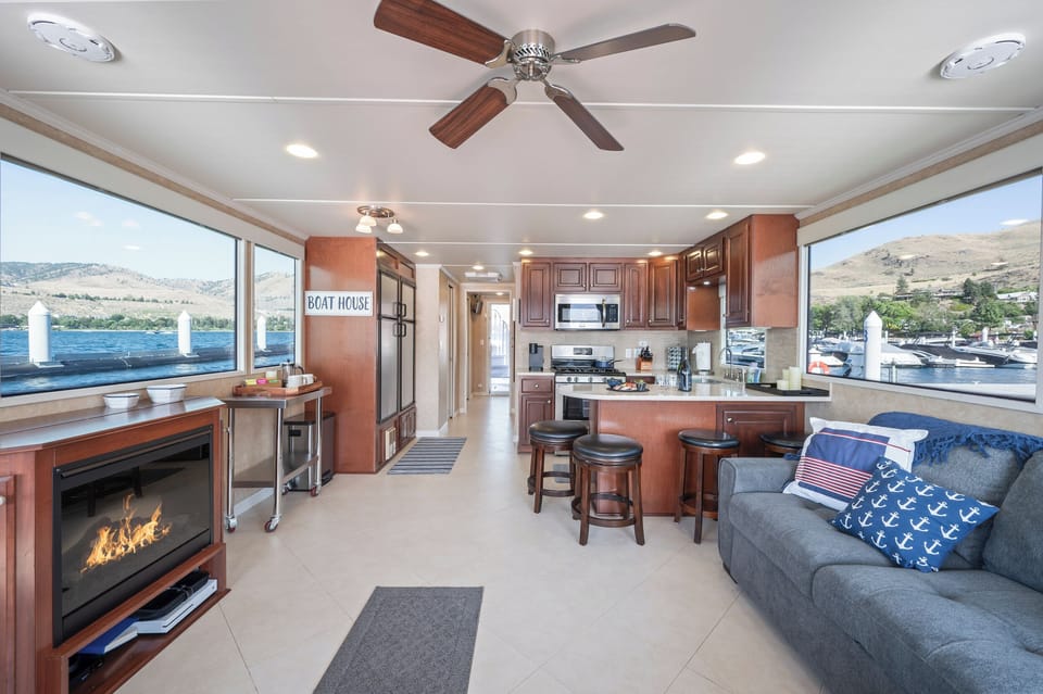 Open living area with pop-up TV, electric fireplace, 4 bar stools and full-size pull-out couch