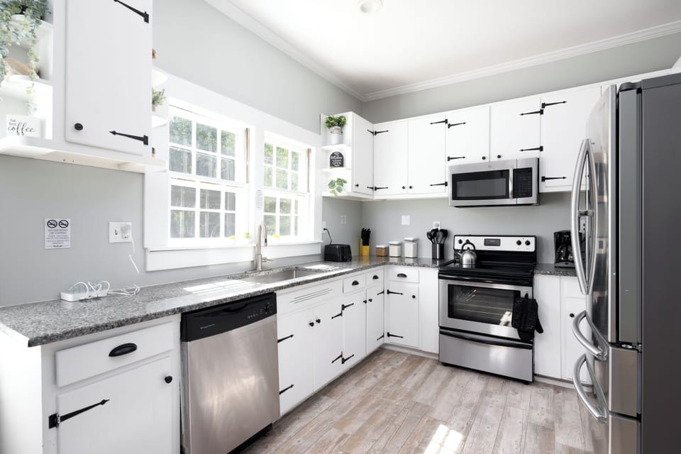 Bright kitchen featuring a large window overlooking the spacious backyard