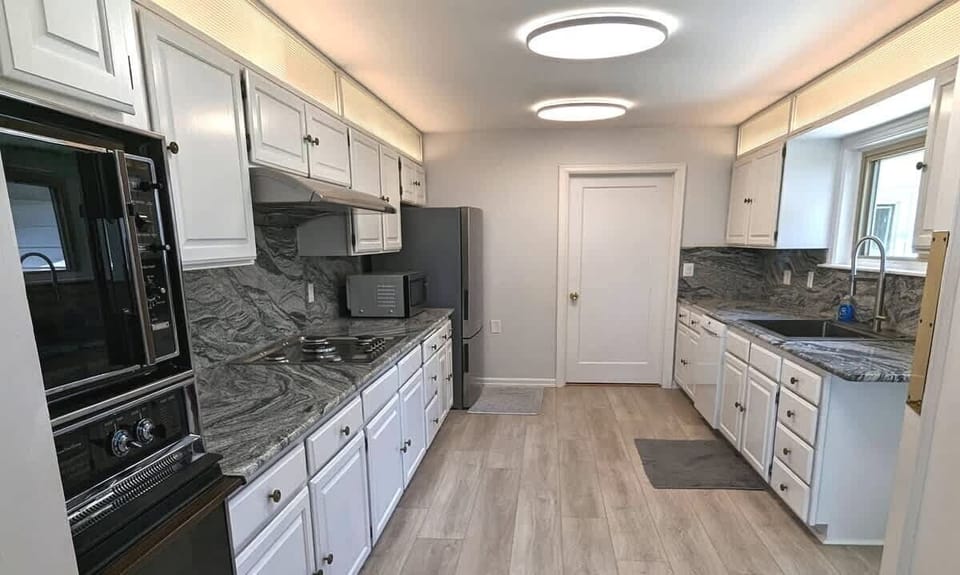 The kitchen has a stove, oven, microwave, toaster, refrigerator & more.
