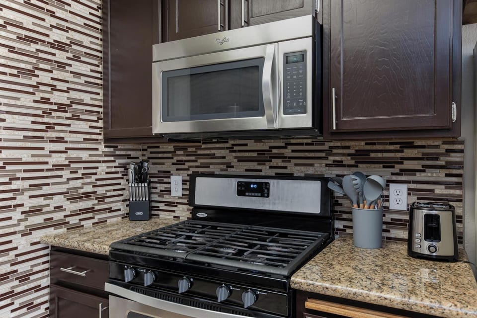 Nice cooking utensils, block of knives with sharpening tool, and toaster.