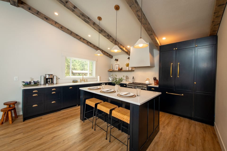 Custom kitchen with large island, gas stove top, custom paneled fridge and dishwasher