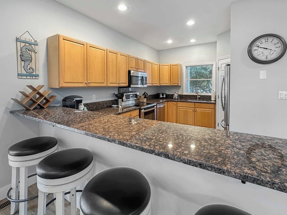 Main Level: Spacious Kitchen w/ Granite Countertops, Stainless Steel Appliances, Ample Cabinet Storage, and Recessed Lighting with Barstools
