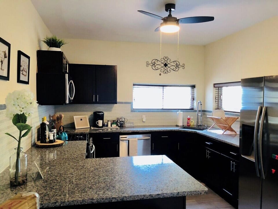 Neat kitchen with kettle, microwave, dishwasher, and more for easy cooking.