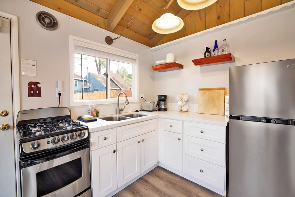 Fully equipped cabin kitchen with ample cabinetry, stove, fridge, and a coffee maker—perfect for cooking meals, morning coffee, and feeling right at home on your stay.