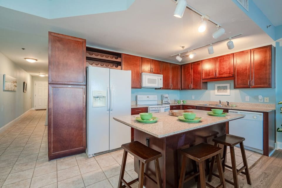 Fully Stocked Kitchen with Drip Coffee Maker and Island Bar Seating