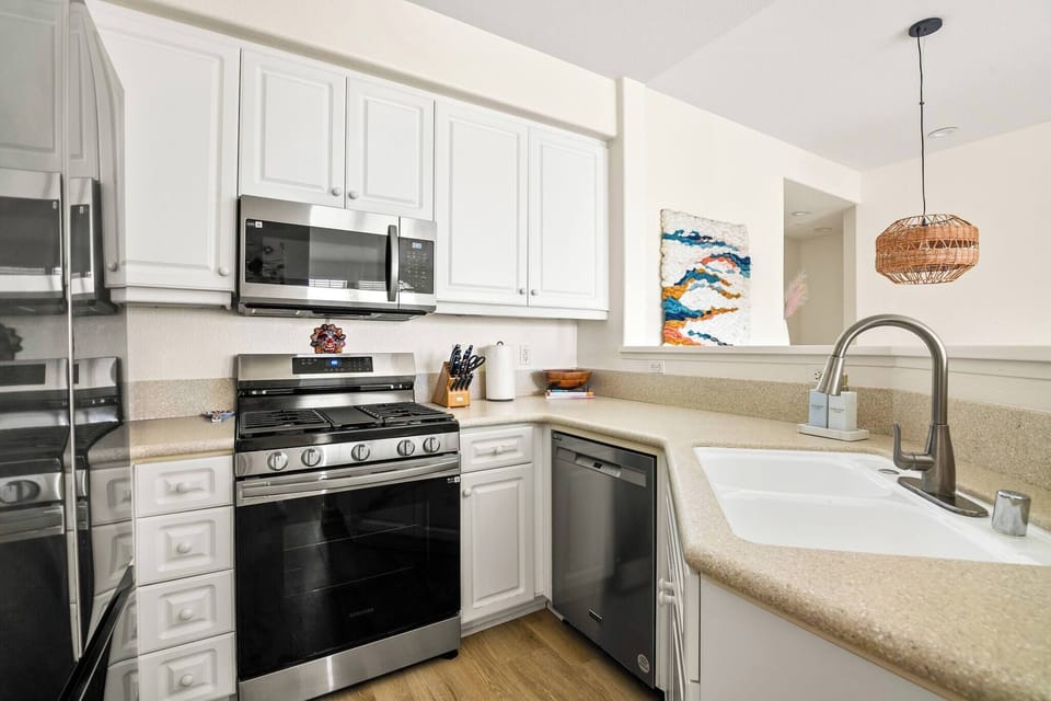 Stainless steel appliances w/white cabinetry and granite countertops