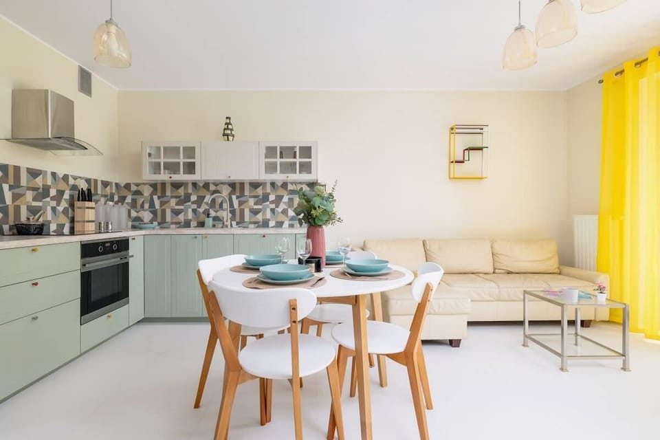 A dining area with a wooden table and chairs, complemented by a bright and airy atmosphere.

