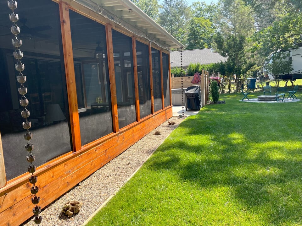 screened in porch with hot tub in background