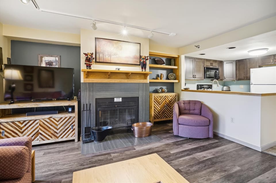 The fully equipped kitchen flows seamlessly into the living room and fireplace area for easy entertaining.