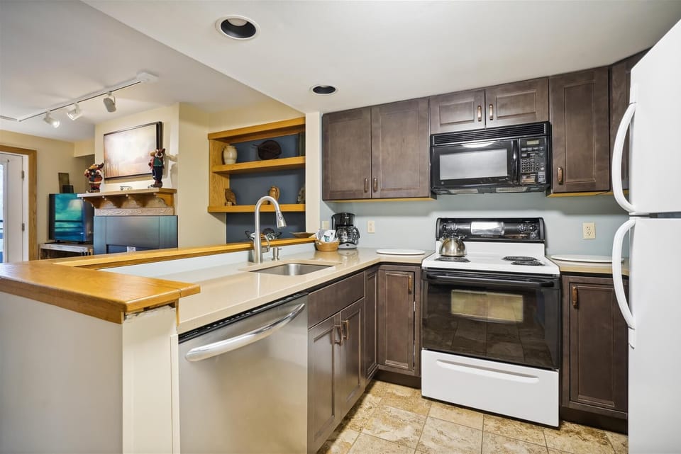 The kitchen features updated cabinetry, generous counter space, and an open layout overlooking the living area.