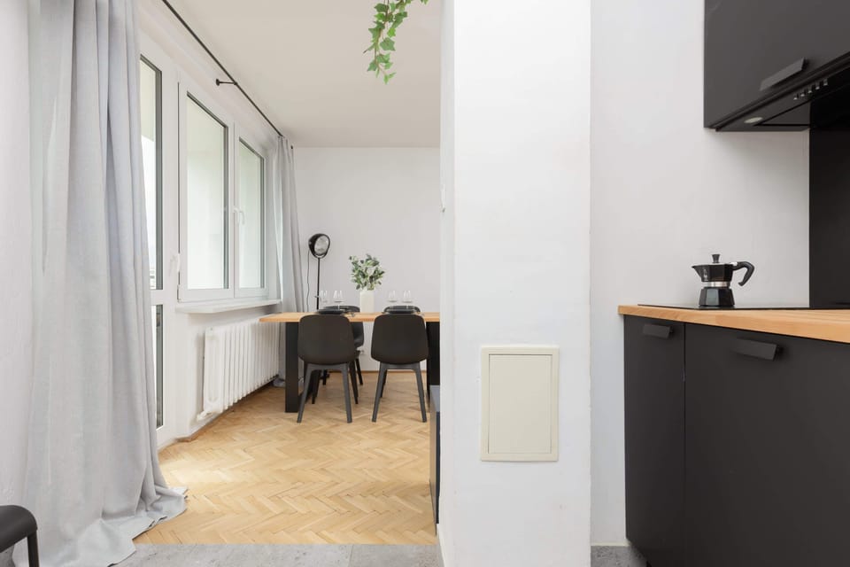 A perspective of the kitchen area connected to the dining room, featuring seamless functionality and modern finishes.

