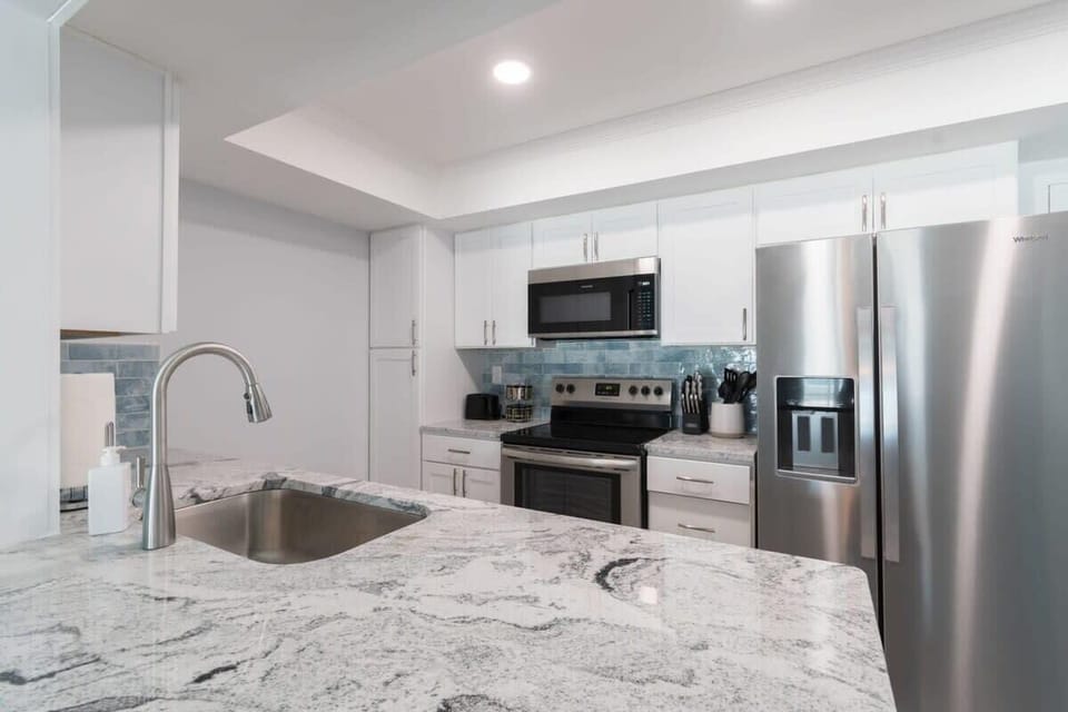 Modern kitchen with stainless steel appliances and granite countertops.