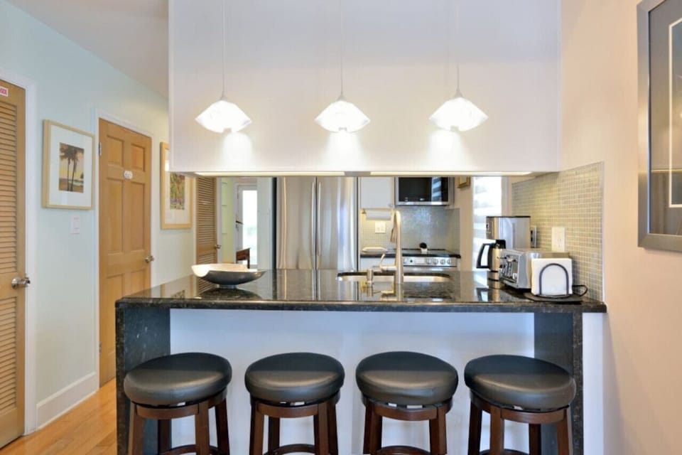 Swivel stools at the breakfast bar looking into the kitchen.