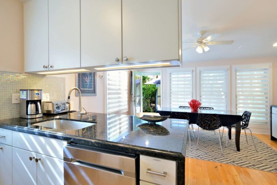 View from the kitchen (black granite countertops), of the dining room and outdoors to your private deck with spa.