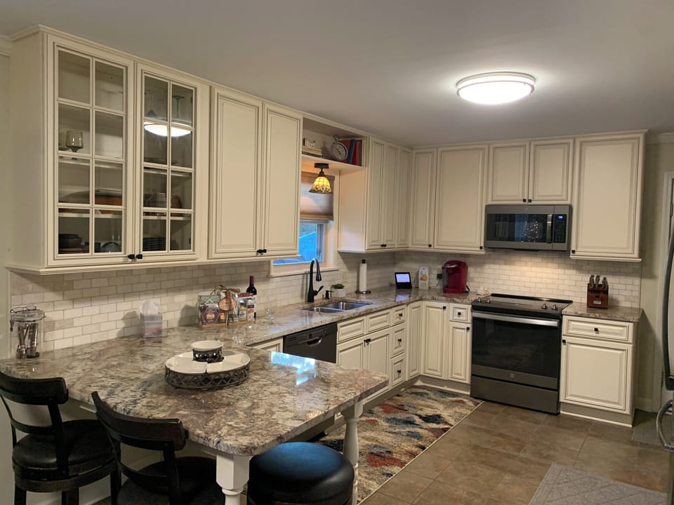 Completely stocked kitchen with new cabinetry, eat at island, and GE appliances.