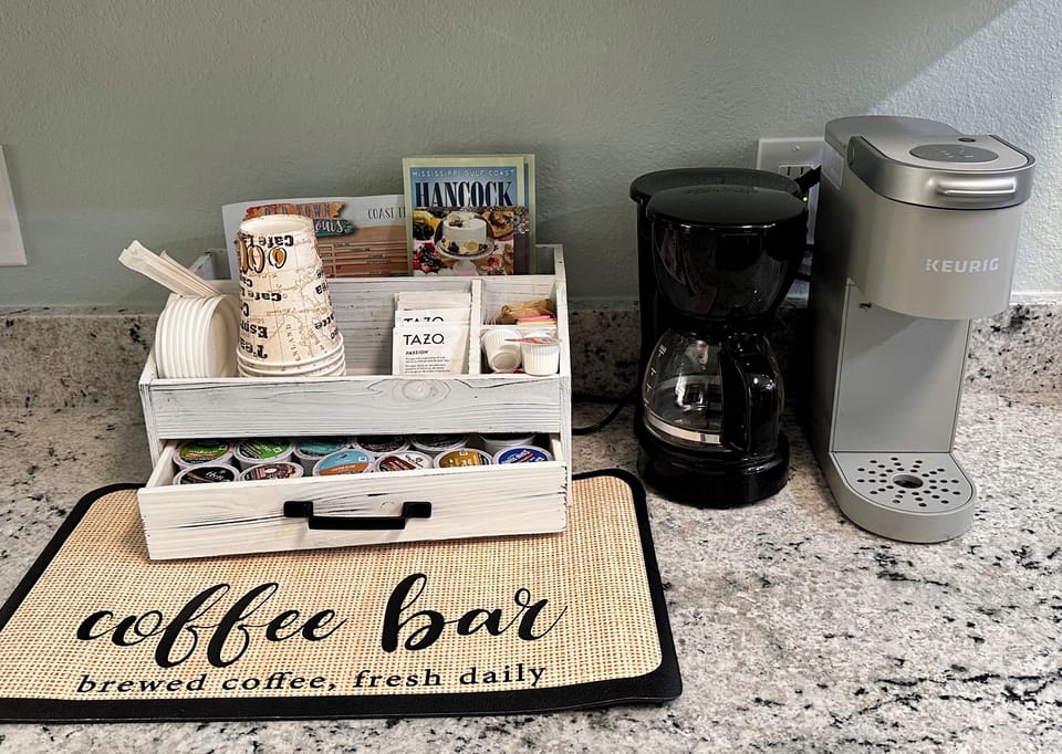 Drip and k-cup coffee makers with sample k-cups, tea, creamer, and sugars 